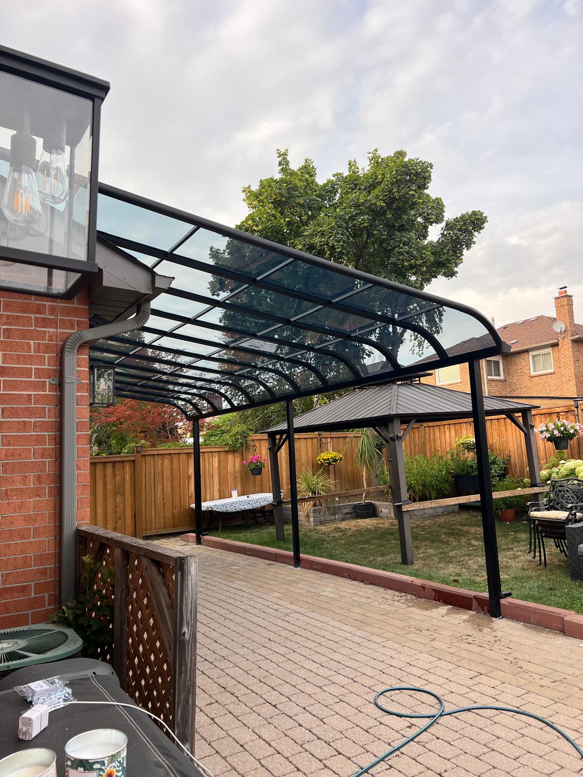 Curved aluminum patio cover along a backyard walkway